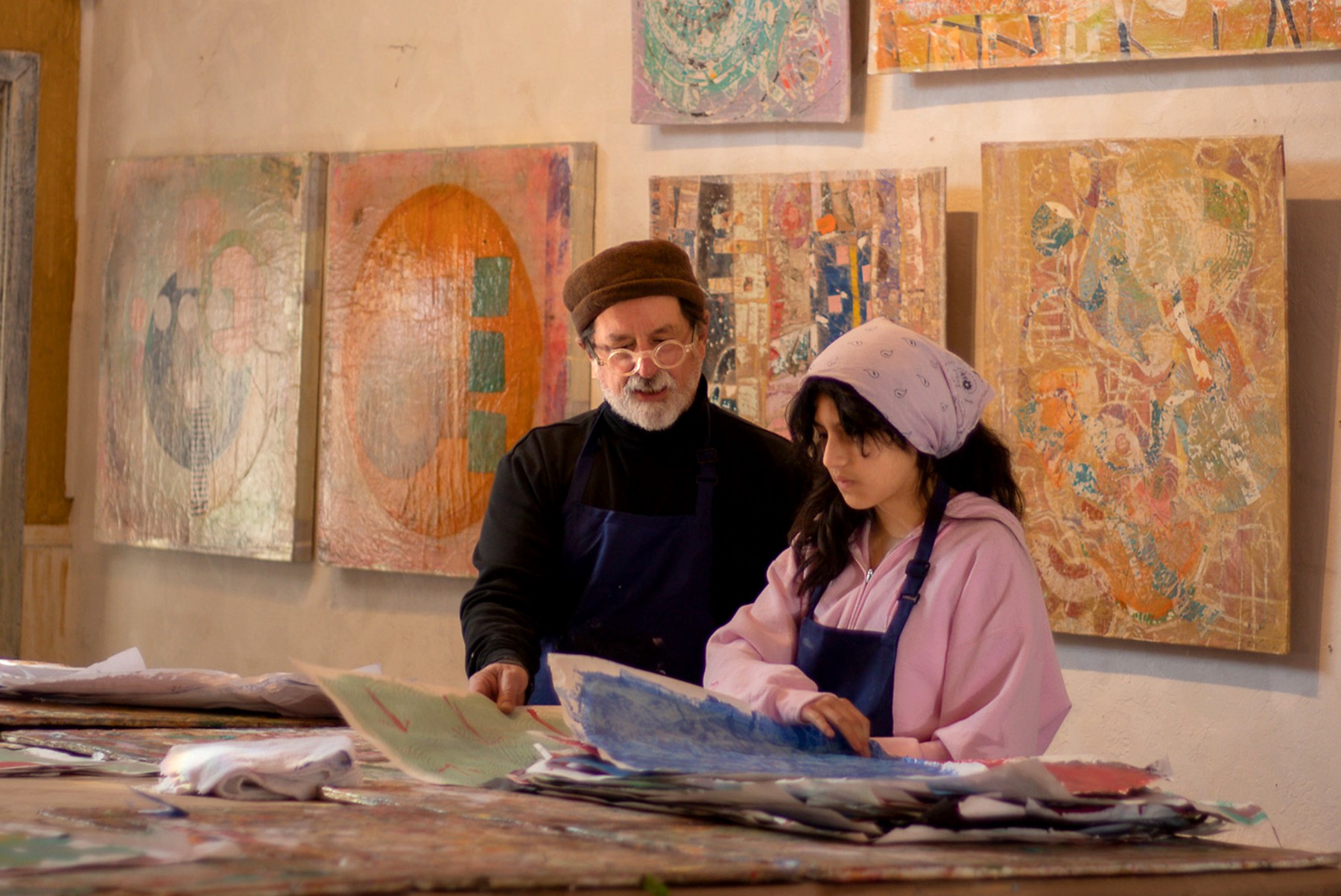 A mentor and student reviewing artwork in a gallery