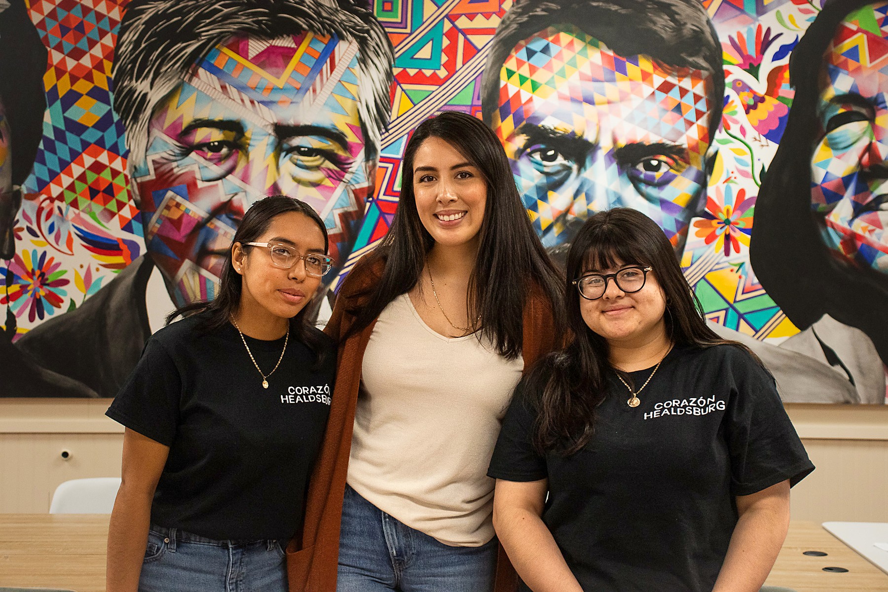 Magnolia program photograph: three people together in front of a colorful mural