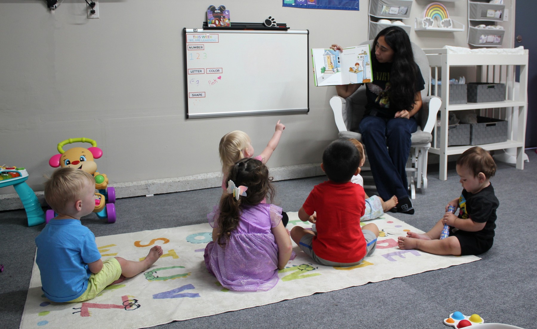 A mentor reading to children seated in a circle