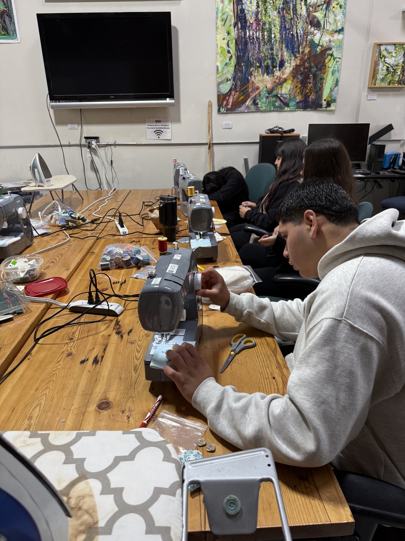 Students working with tools at a craft bench
