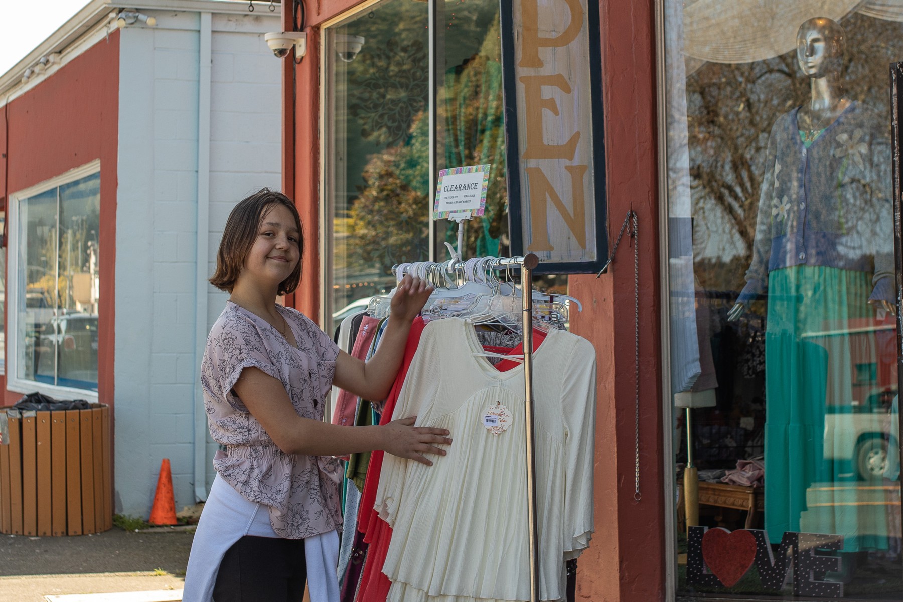 A student arranging clothing outside a local shop
